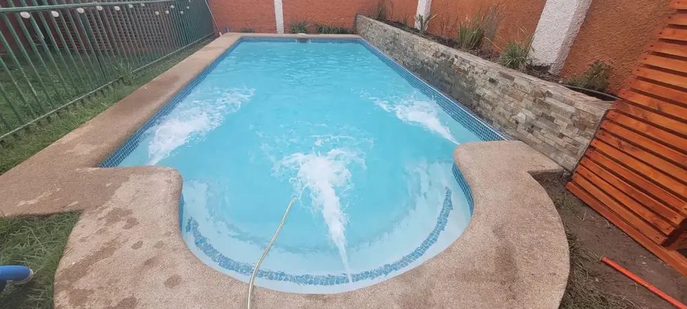 Piscina con revestimiento en cemento-cuarzo SuperBrite terminado, llena de agua